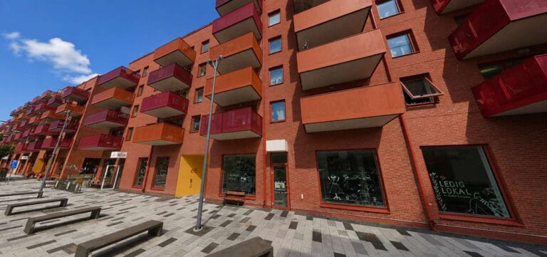 Fasad av ett flerfamiljshus i Mölndal med balkonger och gångväg.