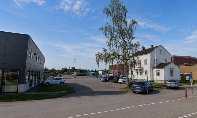 Bilder av en stadsdel i Kalmar med parkeringsplatser och byggnader.