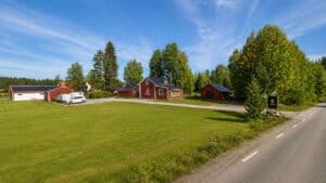 Landsby med röda hus och grönt gräs under blå himmel i Piteå.