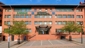Danderyds sjukhus byggnad med parkeringsplats framför.