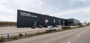 Stor svart byggnad för Karlstad aktivitetscenter med parkeringsplatser framför.