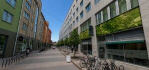 Gatumiljö med moderna byggnader och cyklar vid trottoaren.