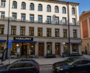 Fasad av en trevåningsbyggnad med butik HärkLippet på bottenvåningen.