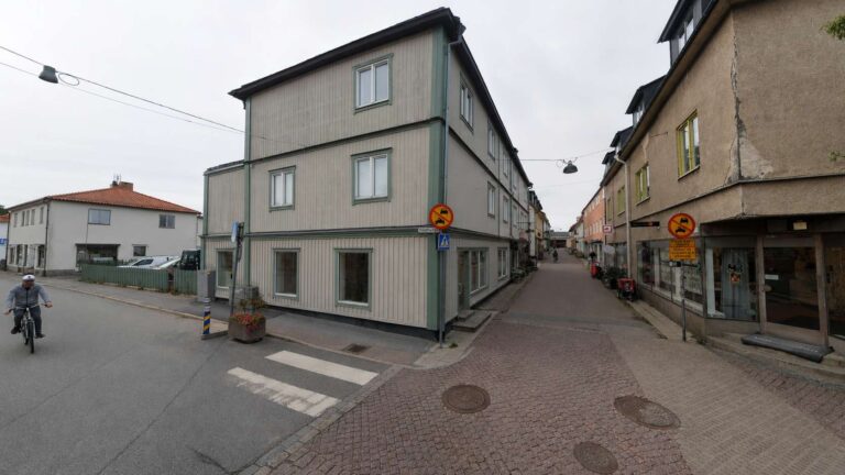Gatubild i Östhammar med byggnader och cyklist.