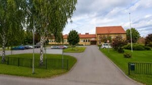 Liten väg leder till en byggnad i Ramsele med gröna omgivningar.