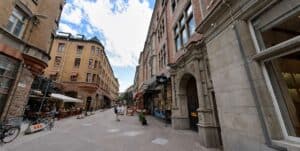 Gatumiljö med gamla byggnader och uteserveringar i Stockholm.