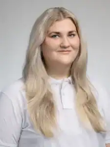 Porträtt av en kvinna med långt blont hår och vit skjorta.