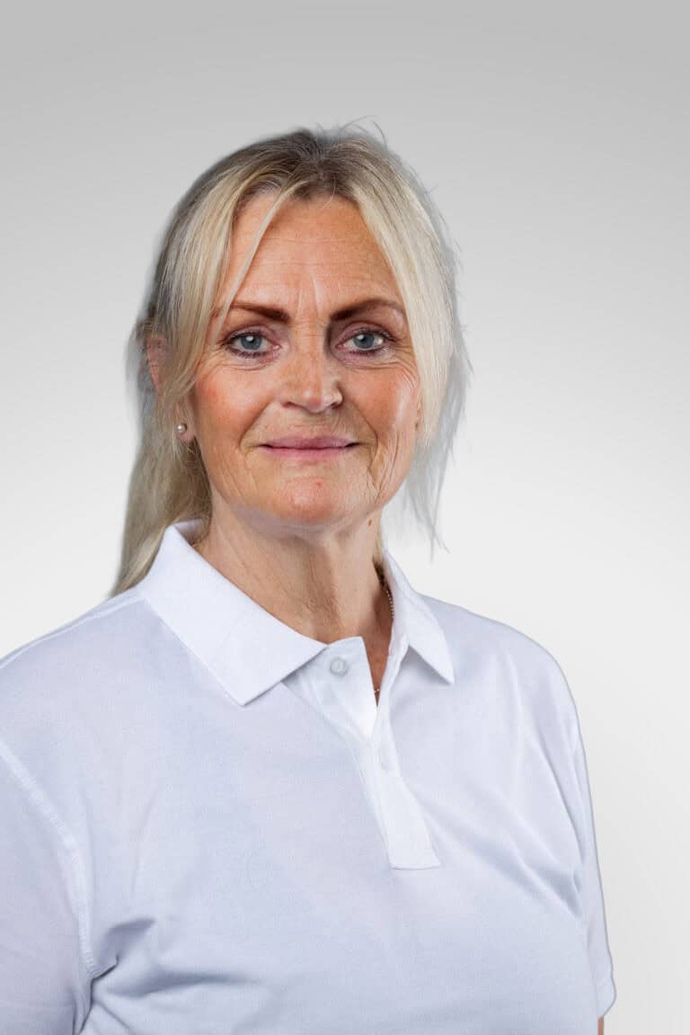 Kvinna i vit polo mot ljusgrå bakgrund.