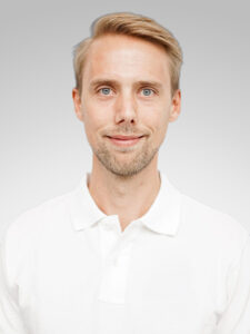 Man i vit skjorta med ljus bakgrund.