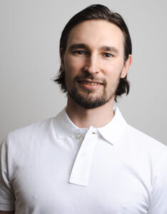 Porträtt av Oskar Berglund i vit skjorta mot ljus bakgrund.