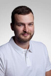 Porträtt av en man i vit skjorta mot ljus bakgrund.