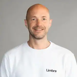 Man i vit Limbrakläder ler mot kameran.