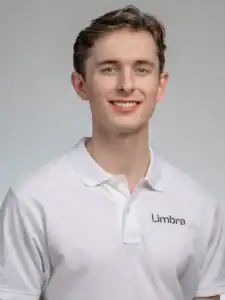 Ung man i vit Limbraklänning med leende ansikte.