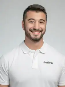 Ung man i vit Limbraklänning med leende ansikte.