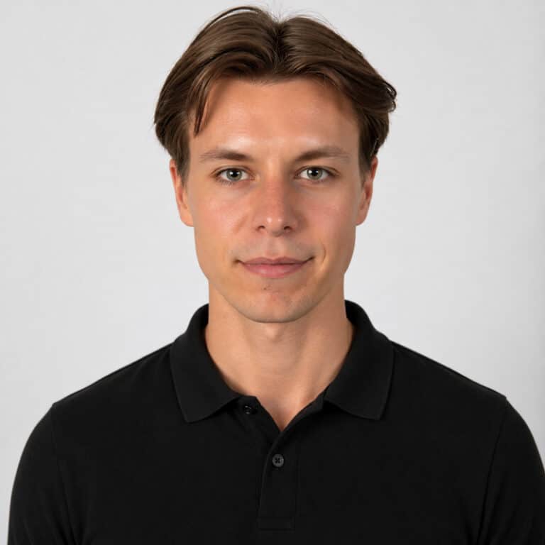 Ung man i svart polo mot ljus bakgrund.