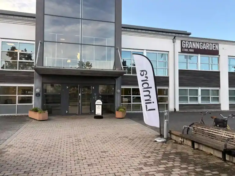 Modern byggnad med glasfasad och flagga utanför.