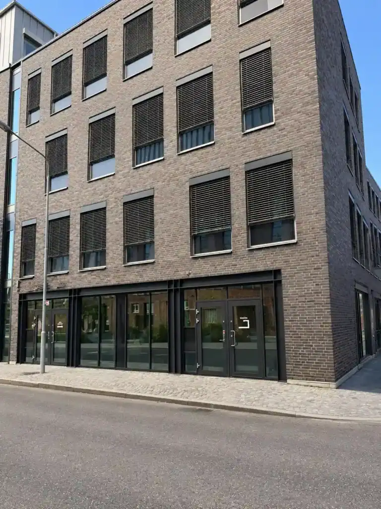 Modern tegelfastighet i Nyhamnen i Malmö med lokal i gatuplan.