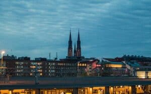Kvällsvy över Uppsala med domkyrkans torn och upplysta byggnader.