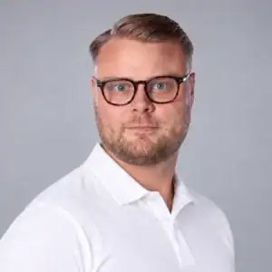 Man med glasögon och vit skjorta, professionell porträttbild.