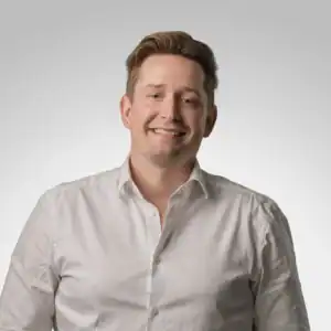 Niklas Hollerup i vit skjorta, leende mot kameran.