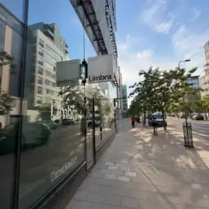 Limbra klinikens skylt på en modern stadsgata med träd och byggnader.