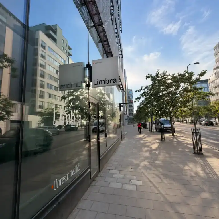 Limbra klinikens skylt på en modern stadsgata med träd och byggnader.