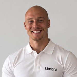 Glad man i vit polo med Limbra-logga, leende mot kameran.