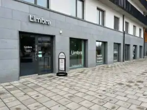 Limbra klinikens fasad med ingångar och skyltar på en grå byggnad.
