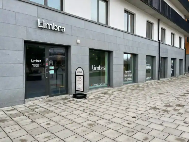 Limbra klinikens fasad med ingångar och skyltar på en grå byggnad.