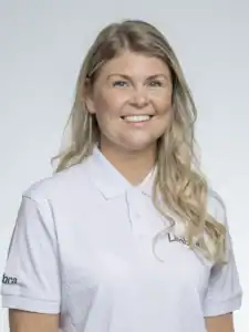 Kvinna med långt blont hår och vit polo som ler mot kameran.