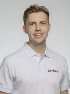 Man i vit polo med Limbra-logga, leende mot kameran.