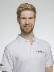 Ung man i vit Limbra-tröja som ler mot kameran.