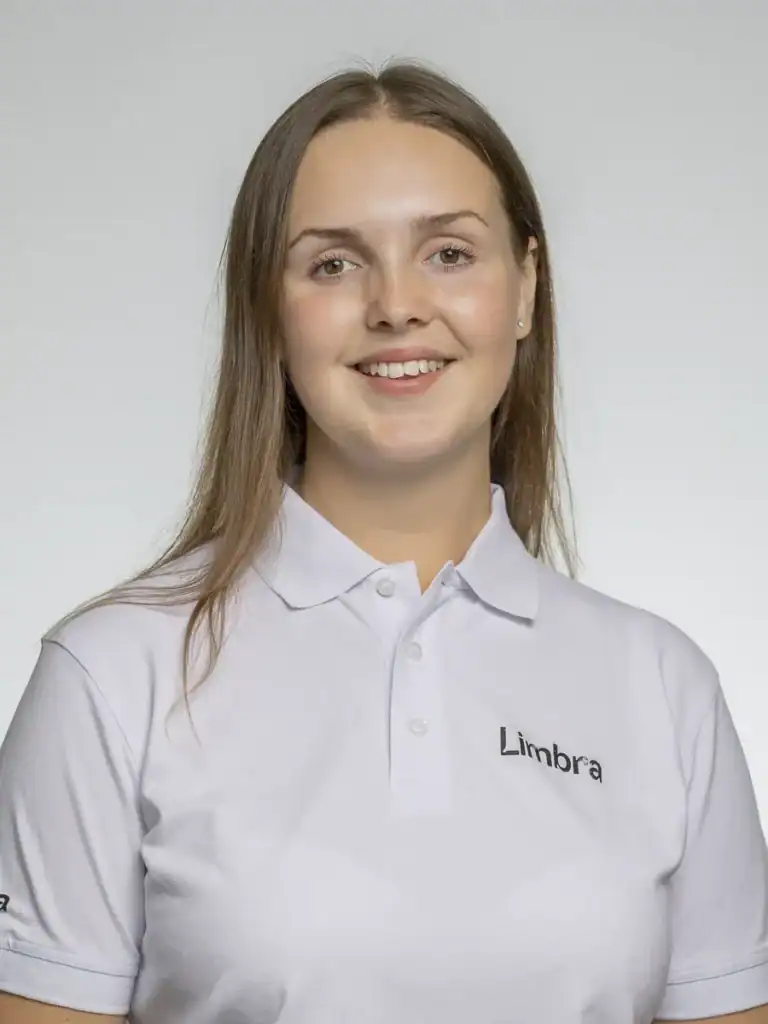 Kvinna i vit Limbra-uniform med leende ansikte.