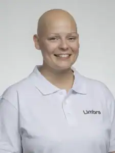 Kvinna med vit polo som ler mot kameran.
