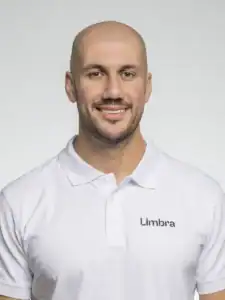 Man i vit polo med Limbra-logga, leende mot kameran.