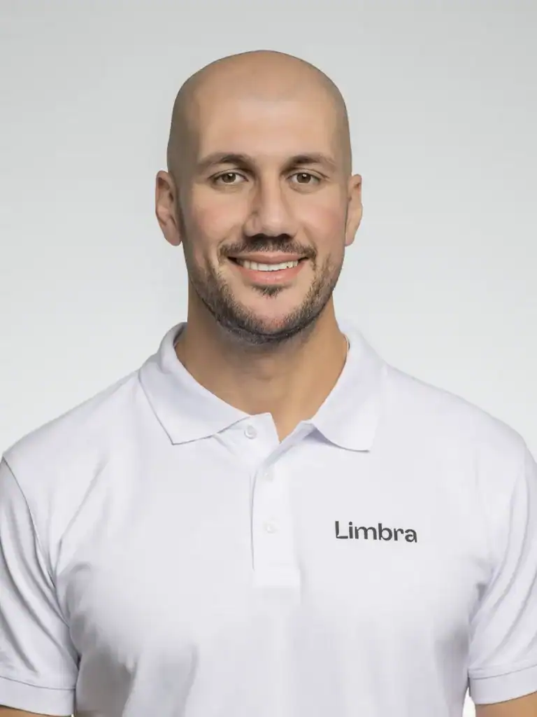 Man i vit polo med Limbra-logga, leende mot kameran.