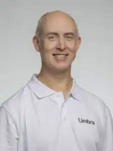 Glad man i vit arbetsklädsel med Limbra-logga.