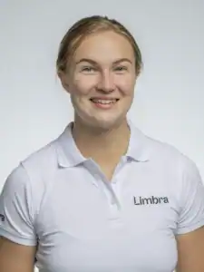Kvinna i vit Limbra-uniform som ler mot kameran.