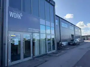 Modern kontorsbyggnad med glasfasad och cyklar utanför.